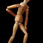 Wooden figure with back pain